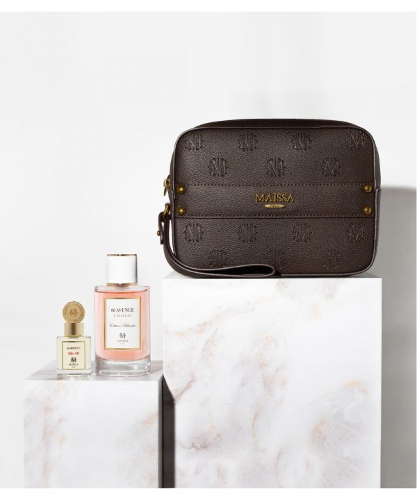 Dieses Bild zeigt das Parfüm-Set von Maison Maïssa mit dem Duft 66 Avenue, dem dazugehörigen Duftöl und einer braunen, sehr hochwertigen Ledertasche. Das Set steht auf Marmortischen, vor einer weißen Wand
