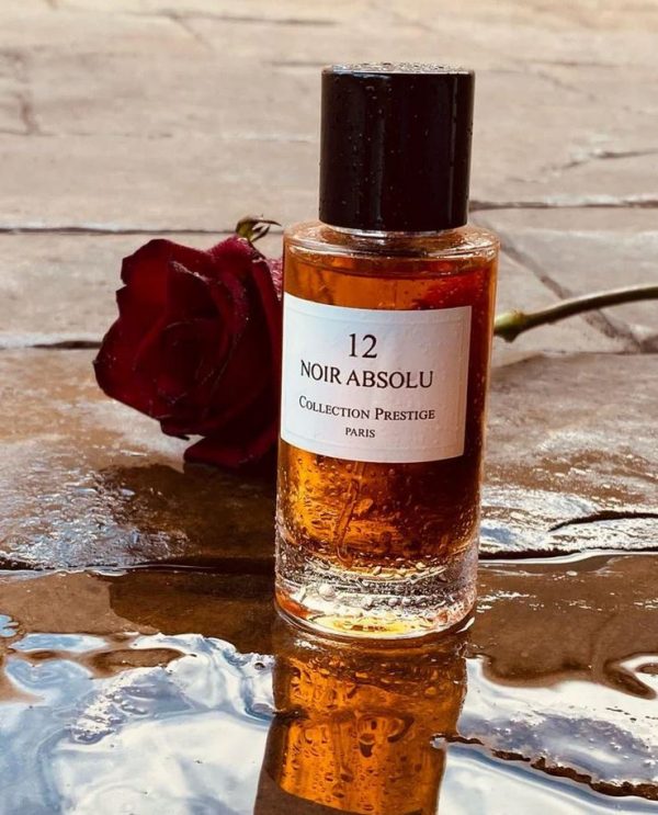 Dieses Bild zeigt das Parfüm der Marke Collection Prestige Nr.3 Noir Absolu, frei stehend, daneben liegt eine rote Rose, der Flacon steht zudem in einer Fütze